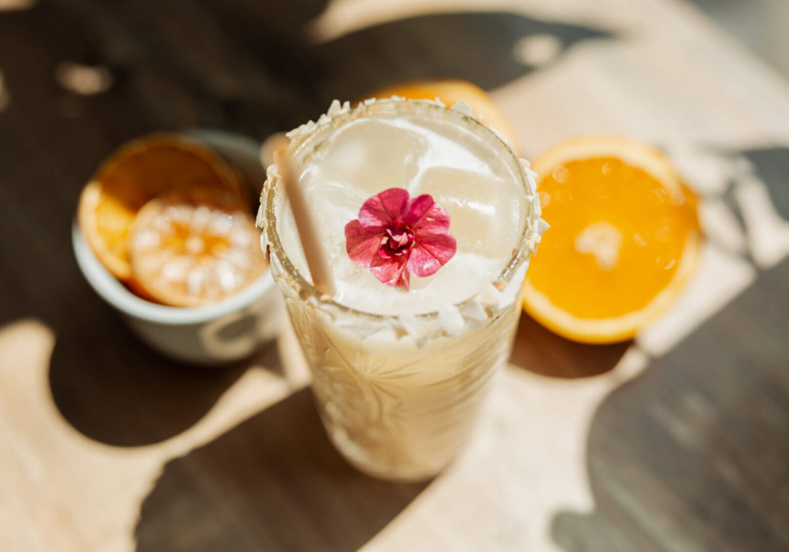 Creamy cocktail with pink flower garnish